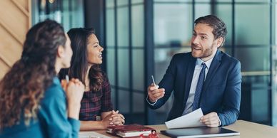 Business meeting with a man explaining documents to two women.