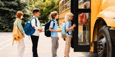 Children lining up to board a school bus.