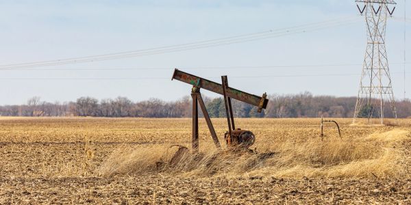 Rusty oil pump in dry field.