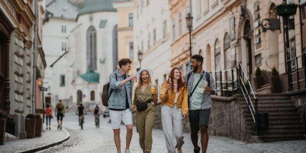 Group of friends walking and laughing on a cobblestone street.