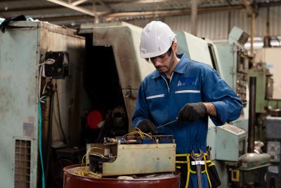 Man in safety gear working with machinery.