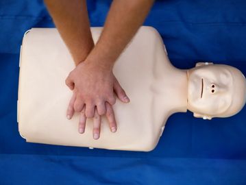 Person performing CPR on a training dummy.