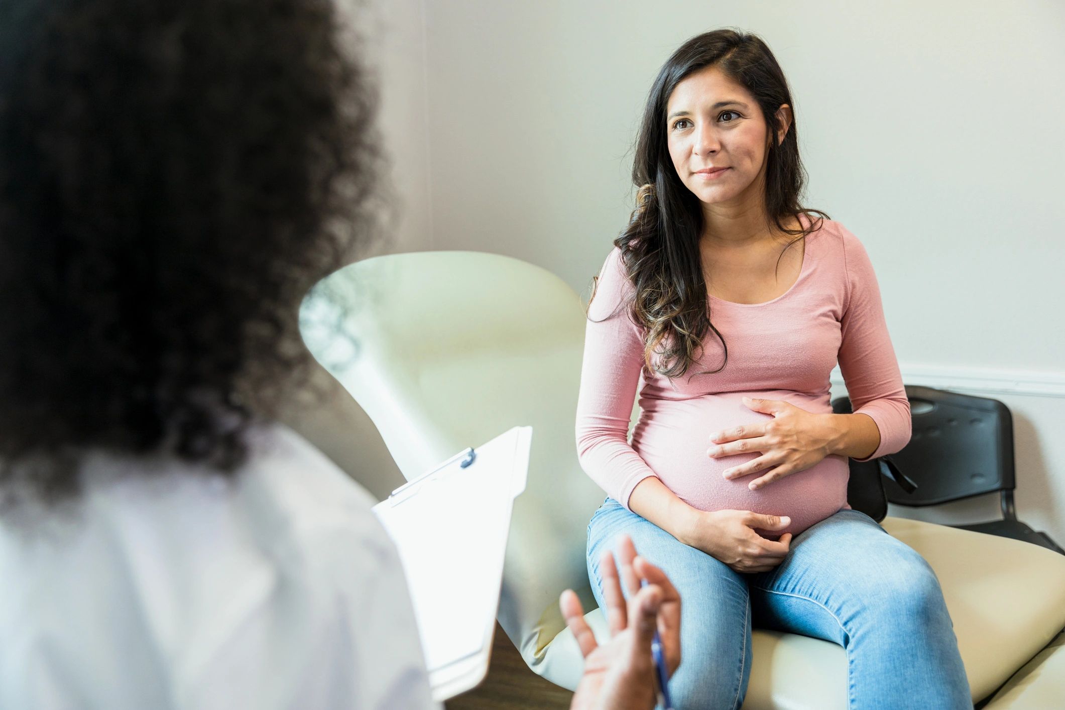 Pregnant woman consulting with healthcare professional.