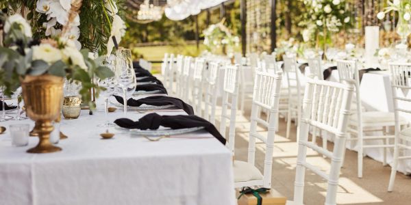 Elegant outdoor banquet setup with white tablecloths and chairs.