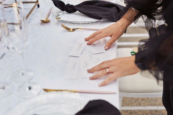 Name cards on an elegant white table setting for an event.