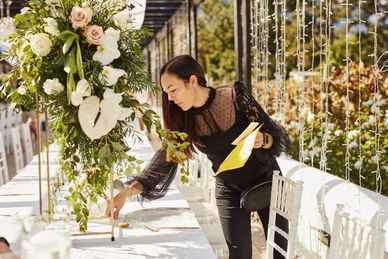 Woman arranging table decorations at an outdoor event.
