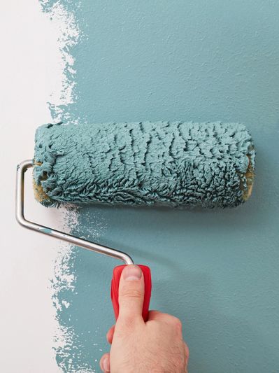 Hand painting wall teal with roller.
