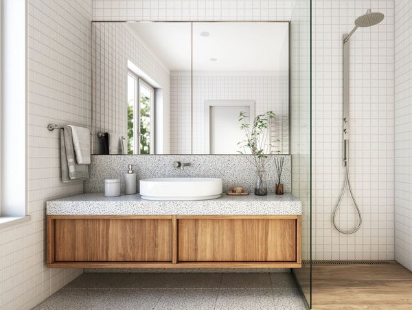 Modern bathroom with wooden vanity and large mirror.