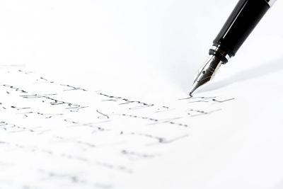 A fountain pen writing cursive on paper.