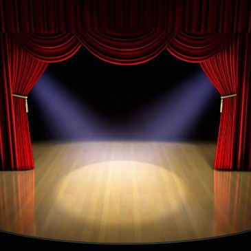 Empty stage with red curtains and spotlights.
