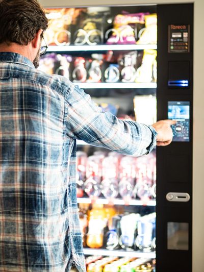 Férfi érintőképernyős snack automatából vásáról