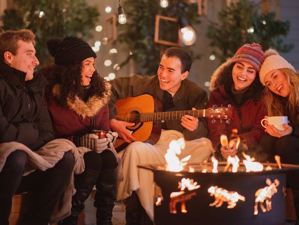 Friends gathering together around a fire
