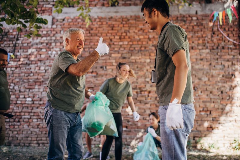 Volunteers showing thumbs up after successful clean up in the park after festival