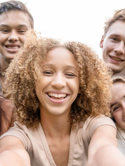Group of friends smiling and taking a selfie.
