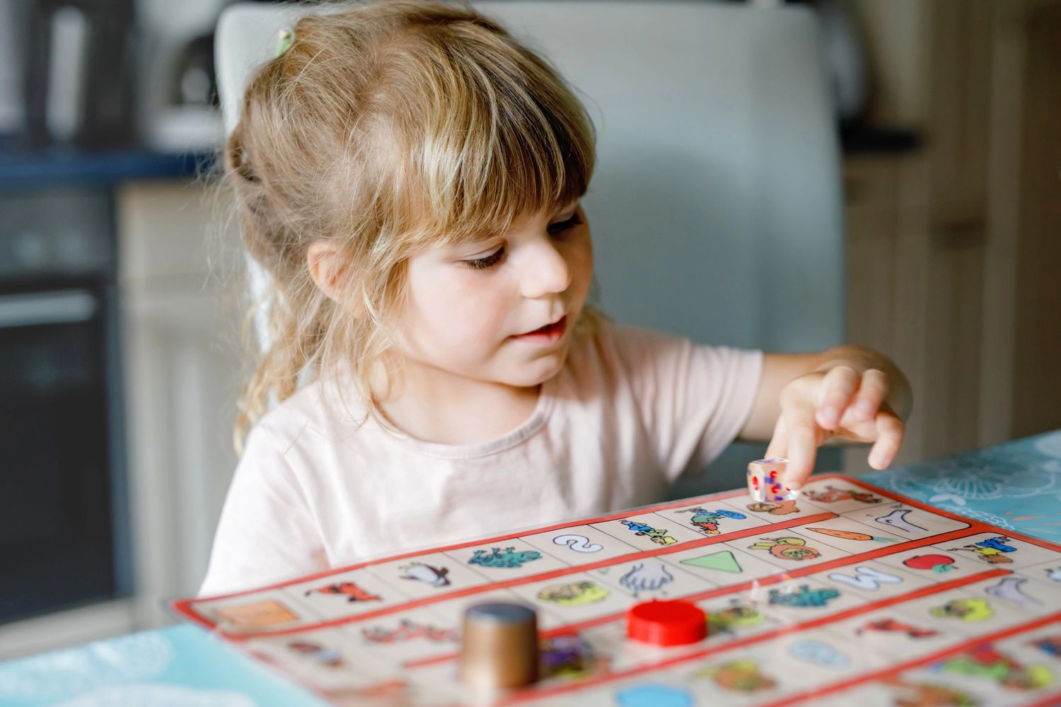 A young girl playing a colorful board game at home.