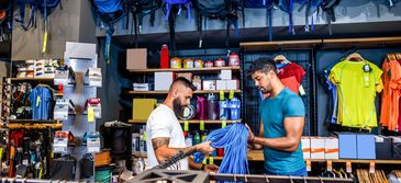 Two men shopping for clothes in a store.