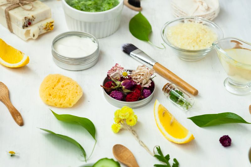 Concept of natural organic ingredients for homemade face and body care products. Essential oils, fruits, vegetables, flowers for skin purifying and moisturizing. White background, flat lay top view