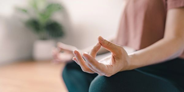 Person meditating with hands in mudra gesture.