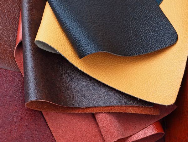 Leather bookbinding materials in different colors used for custom bookbinding and restoration.