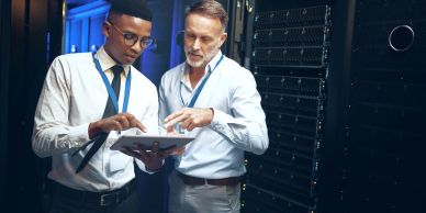 Two IT professionals discussing in a server room.