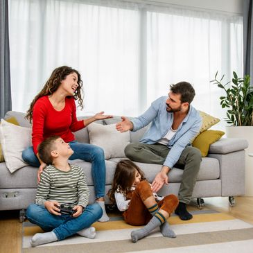 A family happily interacting in their living room.