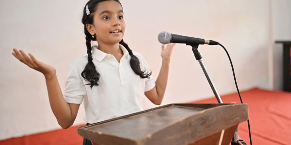 Young girl speaking confidently at a podium.