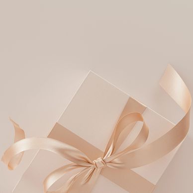 Elegant gift box with a silky peach ribbon on a soft beige background.