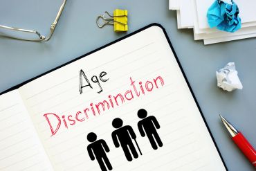 Notebook with 'Age Discrimination' and icons of people.