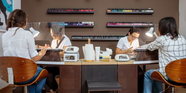 Two women getting manicures at a nail salon.