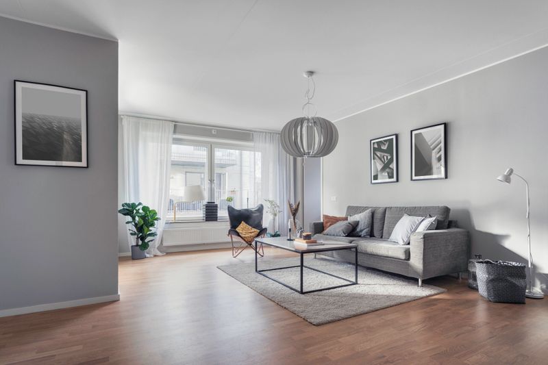 A modern living room with a sofa, table and artwork on the wall.