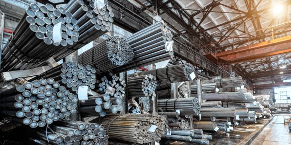 Stacks of metal pipes in a warehouse.