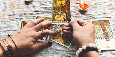 a hand holding a tarot card showing the signage sun