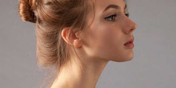 Profile portrait of a young woman with hair in a bun.
