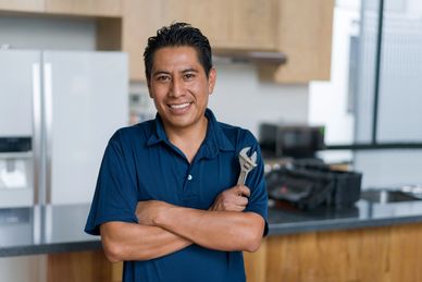 Professional Proline Rooter LLC technician performing emergency drain cleaning under a kitchen sink in a Sacramento home.