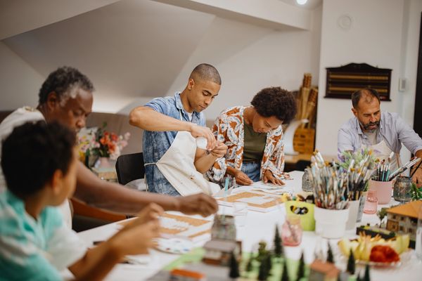 A group of people engaged in arts and crafts at a table.