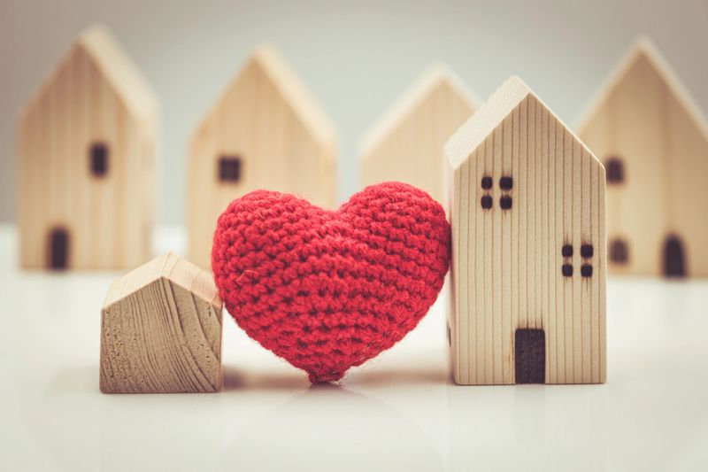 Love heart between big and small house model for stay at home love together and healthy community concept.