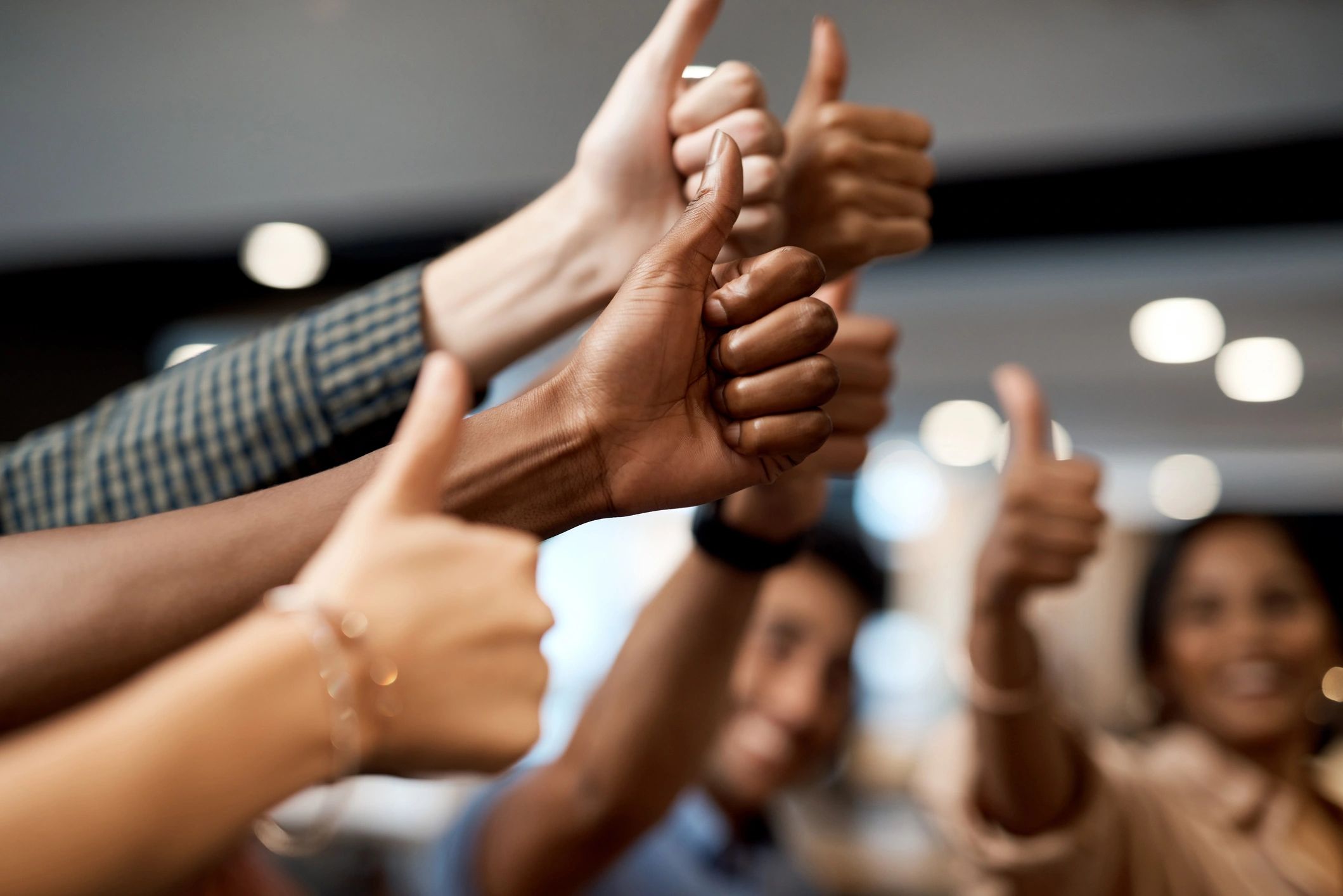 Group of diverse people showing thumbs up together.