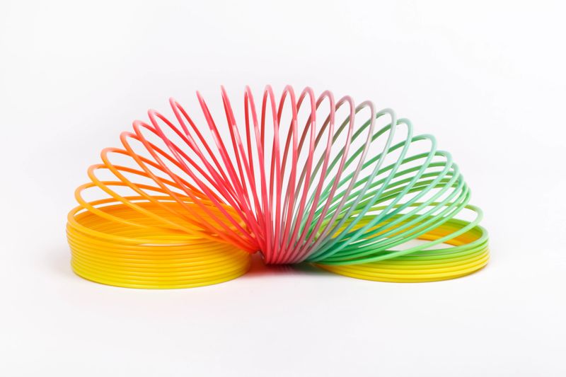 A classic spring toy lies open on a white background.