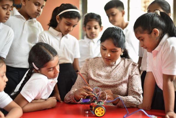 Teacher demonstrates a robotics project to students.