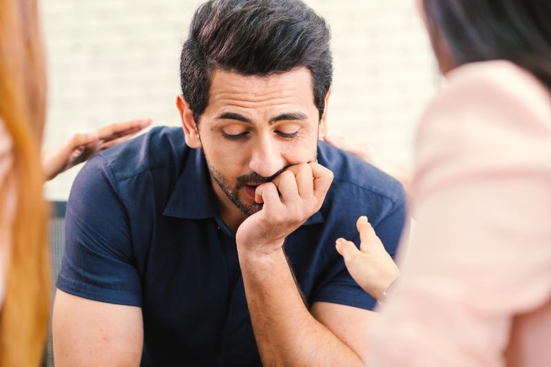 Upset man feel pain depression problem addiction get psychological support of counselor therapist coach diverse people friend group help patient during therapy counseling session concept.