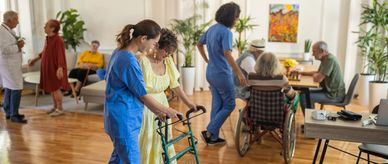 Caregivers assist elderly residents in a bright, welcoming nursing home.