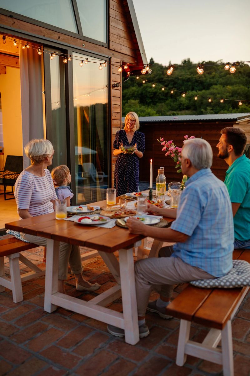 Beautiful multi-generations family enjoying themselves while having a meal together around a table outdoors