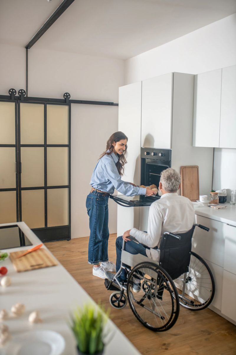 Family morning. Young dark-haired woman preparing breakfast for her disabled husband