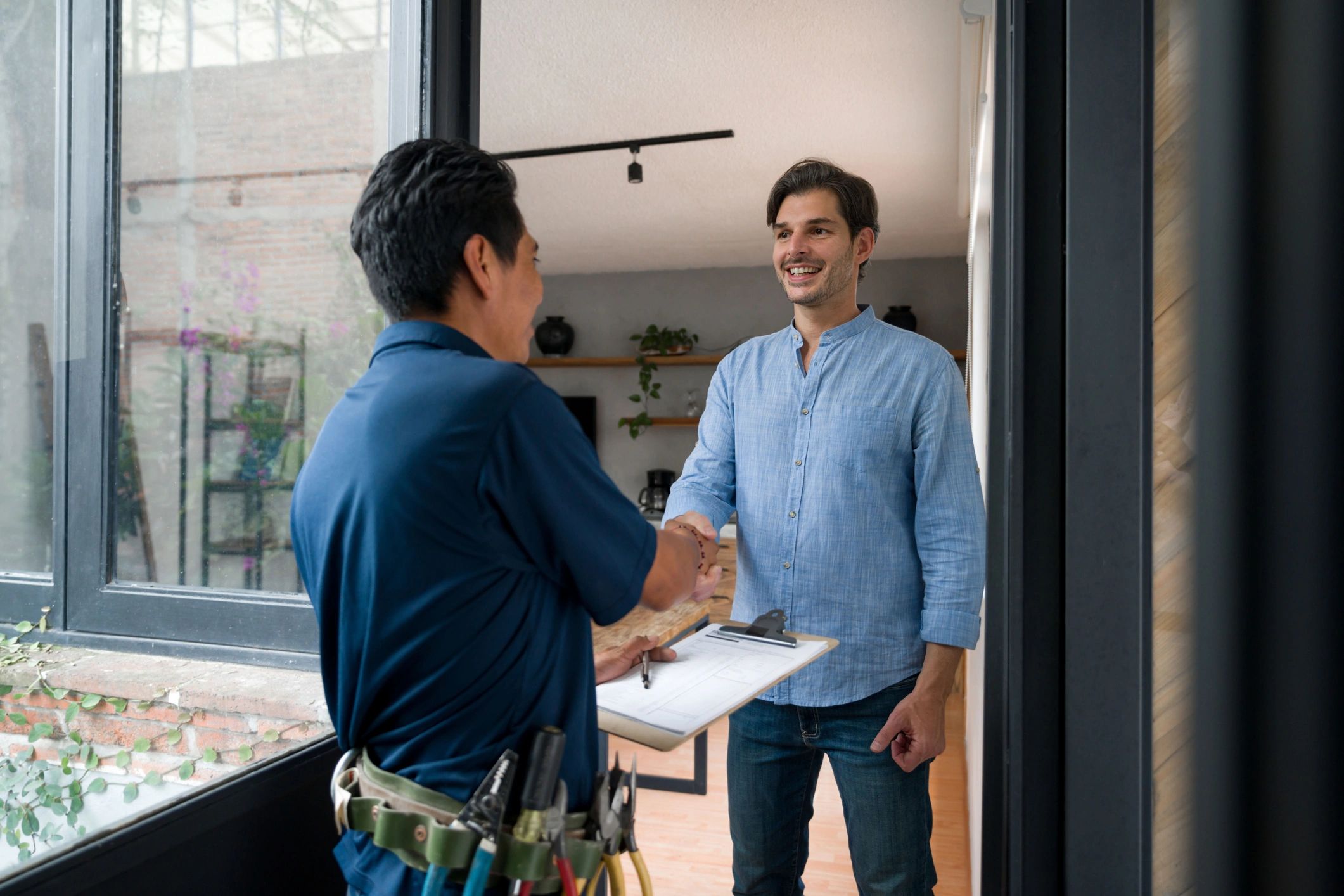 Two men shaking hands during a home service visit.
