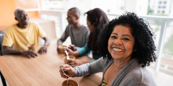 Smiling woman enjoying time with friends at a table.