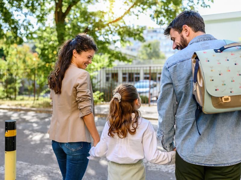 Mother and father taking her daughter to school