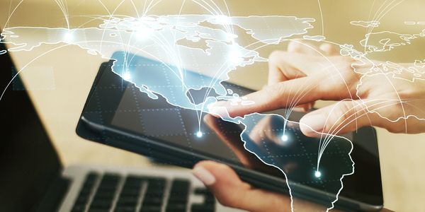 Person using tablet with digital world map and connection points overlay.