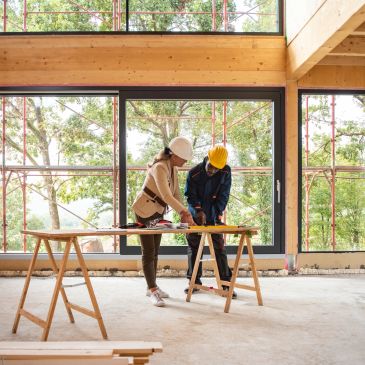 Two construction workers planning inside a building.