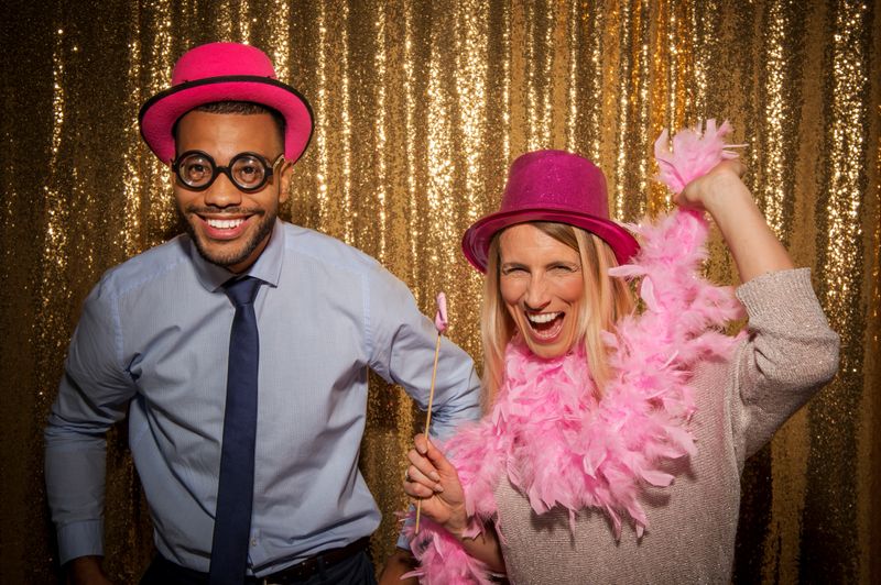 Portrait of cheerful man and woman friends wearing party props during party.