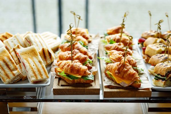 Grilled panini and croissant sandwiches on wooden boards for Toronto corporate catering